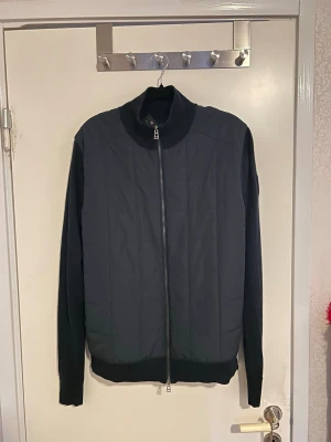 Belstaff mörkblå zip cardigan – strl M - Belstaff mörkblå zip cardigan i storlek M.  Använd endast ett par gånger så i väldigt fint skick. Nypris ca 2500 kr.  Säljer eftersom den inte kommer till användning. Loggan på insidan är lite sliten men inget som syns när man använder den.