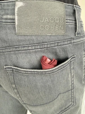 Prisvärda JACOB COHËN jeans - Gråa slim fit-jeans från Jacob Cohën, modell Nick. Tyget är en balanserad blandning med lätt stretch som ger komfort men behåller känslan av klassisk denim. Nypris för modellen ligger runt 3 800 kr (-85%) och skicket är i princip som nytt. Hör gärna av dig vid frågor. Extra sytråd från Jacob Cohën medföljer.