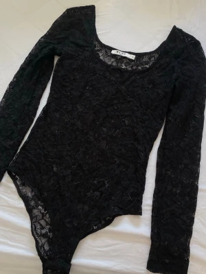 Spetsbody - Svart spetsbody med urringning och en liten rosett🎀endast använd en gång!