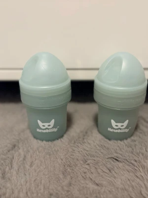 Babyflaskor och nappar plus Rabattkuponger  - Två mintgröna babyflaskor från Herobility med vitt logotryck och två förpackningar nappar från mam och canpol babies, finns även en oöppnad napp från Bibs som inte är med på bilderna. Napparna är i silikon och passar för nyfödda 0-6 månader. Perfekt för småbarnsföräldrar som vill ha praktiska och söta tillbehör. Skickar med även rabattkuponger som jag inte kommer att använda 💝