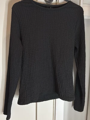 Svart långärmad topp Vero Moda - Säljer en svart långärmad topp från Vero Moda. Toppen har en strukturerad, ribbad yta och rund halsringning. Passformen är normal och materialet känns mjukt och stretchigt, perfekt till många olika outfits. Hör av dig vid frågor!🥰✨ Nypris 299 kr🥰