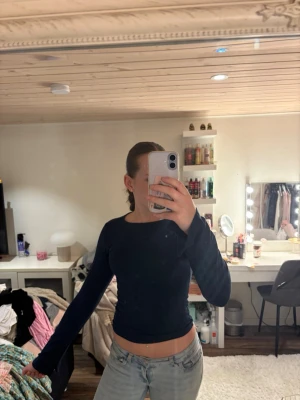 Mörkblå långärmad topp med tumhål - Snygg mörkblå långärmad topp med tight passform och tumhål vid ärmsluten. Perfekt för dig som gillar en enkel men trendig stil. Tunt och mjukt material som känns skönt mot huden.