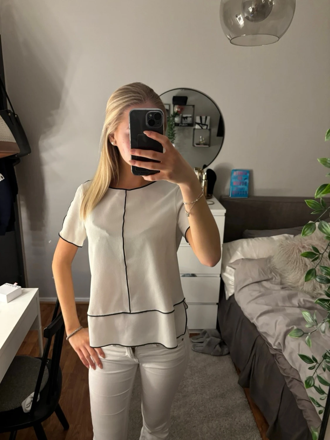 Vit blus med svarta sömmar