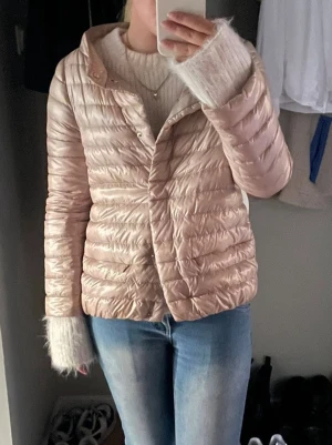 Herno ljusbeige trekvartsjacka  - Säljer en ljusbeige trekvartsärmsjacka med quiltad design. Jackan har en glansig yta och stängs med tryckknappar framtill. Perfekt för alla slags väder. Har även stripes på sidan som man ser på sista bilden. Passar både XS och S