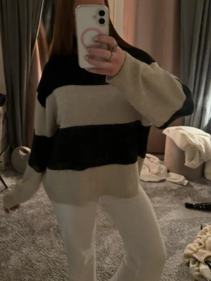 Randig stickad tröja från H&M - Stickad oversized tröja från H&M svart/beige randig. Nästan aldrig använd o inte använts på nått år. 