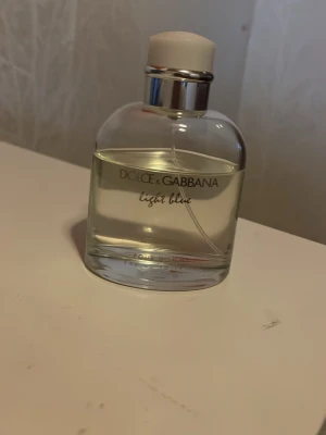 Dolce & Gabbana Light Blue parfym - Säljer en nästan full flaska av Dolce & Gabbana Light Blue Pour Homme Eau de Toilette. Den ikoniska doften för män, känd för sin fräscha och marina karaktär, perfekt för dagligt bruk. Denna flaska innehåller uppskattningsvis 100 ml av 125 ml. Dofter utav Citron, Rosmari och Patchouliblomma. Kartong är ej tillgänglig men du får en sample på köpet.