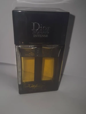 Dior Homme Intense Eau de Parfum - Dior Homme Intense är en lyxig herrparfym i en stilren, rektangulär glasflaska med svart lock. Doften har en djup bärnstensgul färg och flaskan har tydliga, eleganta linjer. Perfekt för dig som gillar exklusiva och moderna dofter.