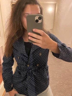 Trench coat  - En prickig trench coat. Jättefin både öppen och stängd.  Dras in fint vid midjan. Precis som ny. Jag har storlek xs/s i jackor denna är i 152 barnstorlek men passar perfekt. 