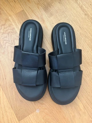 Svarta sandaler från Vagabond - Stilrena svarta sandaler från Vagabond med breda korslagda remmar i läder och chunky sula. Snygg slip-in modell som ger en modern look och passar perfekt till sommarens outfits. Mjukt vadderad fotbädd för extra komfort.Typ aldrig använt ☺️