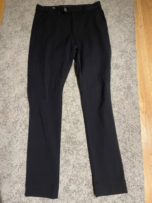 Mörkblå kostymbyxor med slimfit - Snygga mörkblåa kostymbyxor med svaga linjer lodrätt. Smal passform och klassisk design. Perfekta för en stilren look.