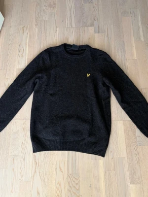 Svart stickad tröja från Lyle & Scott - Mörkgrå stickad tröja från Lyle & Scott då den inte kommer till användning längre.