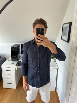 Mörkblå linneskjorta från Park Lane - Snygg mörkblå skjorta i 100% linne från Park Lane. Klassisk krage, knäppning framtill och lång ärm.  Diskret logga broderad på bröstet. Hör gärna av dig vid frågor!