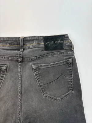 Grå smala jeans från Jacob Cohen - Snygga grå jeans från Jc med smal passform och klassisk femficksdesign. Jeansen har en diskret tvättad look och svart patch med jc-logga bak i midjan. Tillverkade i mjukt denimtyg som ger en bekväm känsla och modern stil.