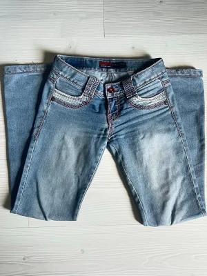 Supersnygga lågmidjade jeans - Så snygga super lågmidjade jeans med rosa detaljer. Sitter så fint på. Säljer då de är för små för mig 😪. Är lite rivna längst ner och finns 2 små fläckar (allt syns på bilderna) men annars i super skick. Verkligen så snygga!!