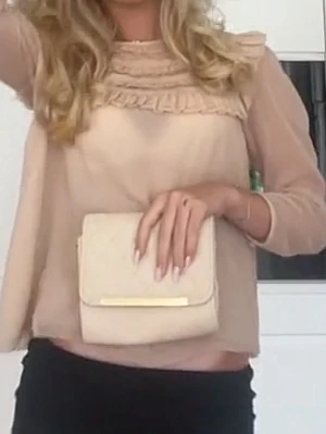 Ljus rosa blus med volangdetaljer - Söt ljus rosa blus i transparent material med volangdetaljer vid halsringningen. Det är en flowy passform som ger en romantisk vibe. Perfekt att styla med svarta byxor eller kjol.