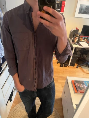 Mörkgrå linneskjorta - Snygg mörkgrå skjorta i linne liknande material med klassisk krage. Skjortan har en bröstficka och långa ärmar som kan vikas upp för en mer avslappnad look. Perfekt för sommar!☀️☀️