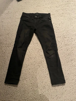 Svarta slim fit jeans från replay - Säljer ett par svarta slim fit jeans från replay med klassisk femficksdesign och snygga detaljer. Jeansen har en rak passform och är tillverkade i stretchigt denim som ger en skön känsla. Perfekta för dig som gillar en stilren look. De är i storleken 14a men sitter ungefär som 12a då de är uppsydda. Det går även att köpa alla 3 replay jeans på min profil för 900!