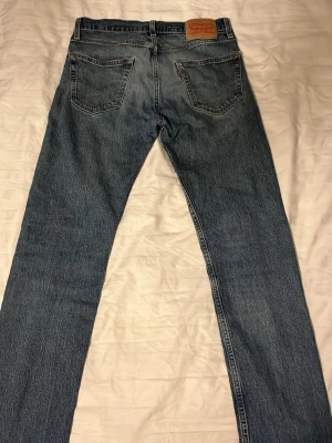 Levi's 502 - Klassiska blå jeans från Levi's med rak passform och femficksmodell. Jeansen har en snygg tvättad look och är tillverkade i slitstarkt denimtyg. Perfekta för en avslappnad och tidlös stil.