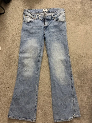 Ljusblå bootcut jeans från 157 - Säljer ett par ljusblå bootcut jeans från 157 med klassisk femficksdesign och dubbla knappar i midjan. 