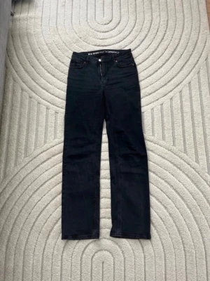 Svarta mid wide jeans midja 26 längd 32 - Säljer ett par svarta jeans med mid wide passform, midja 26 och längd 32. Jeansen har klassisk femficksdesign, dragkedja och knapp framtill. Perfekta för dig som gillar en lite rakare och avslappnad stil. Byxorna är mörkgråa, något mer åt de svarta hållet🥰