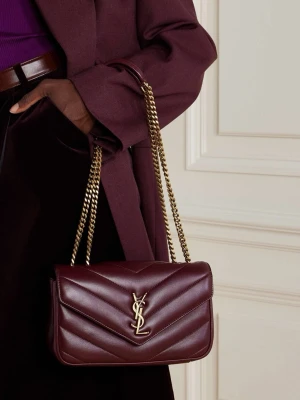 Vinröd YSL handväska i läder - Säljer en snygg vinröd handväska från Saint Laurent med klassisk YSL-logga i guld framtill. Väskan är tillverkad i quiltat läder och har en kedjerem i guld som kan bäras på axeln eller crossbody. Perfekt accessoar för att lyfta din outfit.