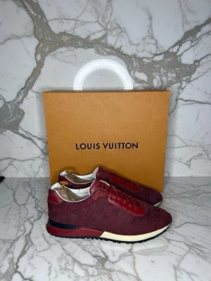 Röda Louis Vuitton sneakers - Snygga röda sneakers från Louis Vuitton med ovandel i textil och läderdetaljer. Skorna har vita och svarta sulor samt diskreta monogramdetaljer. Perfekta för dig som vill sticka ut med exklusiva och trendiga sneakers. 