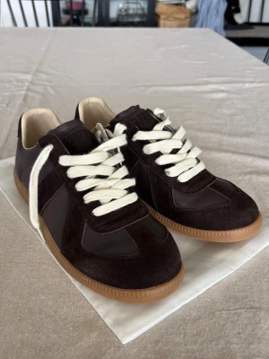 Maison Margiela GAT - Feta GATs från Maison Margiela i en fin brun färg. De är i princip nya. Kommer med dustbag.Storlek 42 passar 41-43. Byten är alltid intressant!