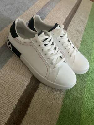 Dolce & Gabbana vita sneakers - Snygga vita sneakers från Dolce & Gabbana, skorna är i princip helt nya och användes endast en gång till ett kalas men kände att de it passade för att användas fler gånger där av säljer jag de, pris kan diskuteras vid snabb affär, frågor är ba att skriva, strl 46 sitter som 45👍👍👍