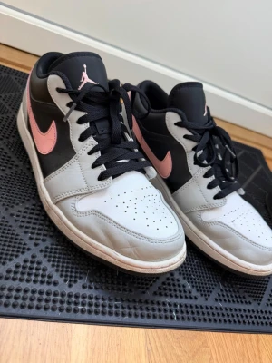 Nike Air Jordan 1 Mid grå/svart/rosa - Säljer ett par Nike Air Jordan 1 Mid sneakers i grått, svart och rosa, skorna är i väldigt bra skick. Inkl box och kvitto