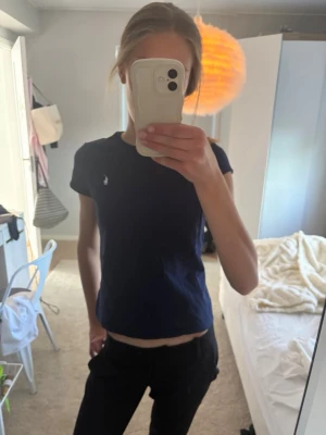 Mörkblå t-shirt från Ralph Lauren - Mörkblå t-shirt från Polo Ralph Lauren med klassisk passform och liten broderad logga på bröstet. T-shirten har rund halsringning och är tillverkad i mjuk bomull.