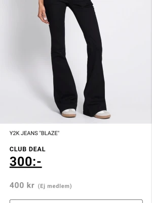 Svarta utsvängda Y2K-jeans Blaze - Säljer ett par svarta Y2K-inspirerade jeans från Blaze med utsvängda ben och hög midja. Jeansen har en clean look utan slitningar eller detaljer och passar perfekt till en trendig streetwear-stil.