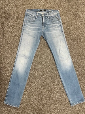 Replay Anbass Jeans – Ljusblå – W29 L32 - Säljer ett par ljusblåa Replay Anbass jeans med riktigt snygg tvätt. Har en arch-style / markerad fade med fina streck som ger jeansen en väldigt snygg och stilren look. Väldigt lite använda och i väldigt bra skick.  • Märke: Replay • Modell: Anbass • Storlek: W29 L32 • Färg: Ljusblå • Skick: Väldigt bra skick, ytterst lite använda • Passform: Slim fit  Nypris runt 1500–1800 kr i butik.  Pris: 499 kr