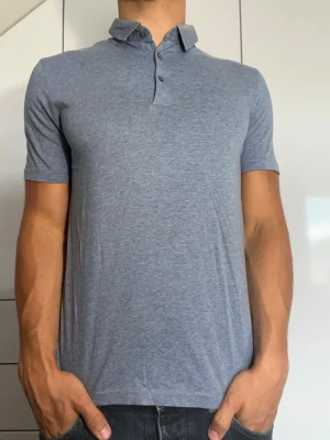 Blå pikétröja från COS - Ljusblå piké från COS. Strl S. Tecken på användning syns t ex vid krage. Modellen är 178 cm och väger 77 kg. Hör gärna av dig vid frågor!