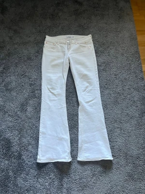 Vita bootcut jeans med låg midja  - Jättefina lågmidjade bootcut i stolek 31/32 jeans ifrån jukyard. Pytte lite slitna nere vid benen men inget man tänker på. Även en liten smink fläck jämte gylfen (som man ser på bilden) men går säkert bort i tvätten🙌🏻 Annars är de jättebra i skick och supersnygga!!💓