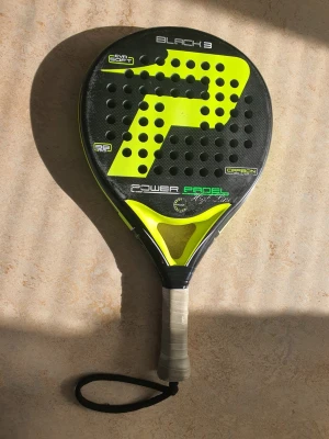Power Padel Black 3 padelracket - Säljer ett Power Padel Black 3 padelracket i svart och neon-gul färg. Racketen har EVA soft kärna, är tillverkad i kolfiber och har ett grepp med handledsrem. Perfekt för dig som vill ta ditt padelspel till nästa nivå.