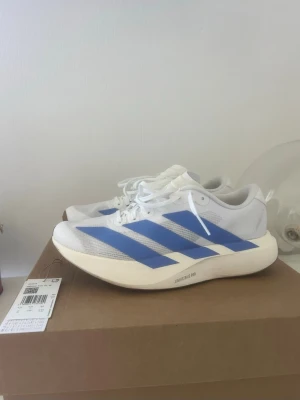 Adidas Adizero Evo SL storlek 40 - Jag säljer mina adidas adizero Evo SL löparskor, som köptes nu i maj. De är storlek 40, dam. Endast använda en gång när jag testsprang dem 5 km, men insåg att de tyvärr inte passade mig. Därmed i nyskick!   Nypris är 1700kr.  De är i färgen cloud white/blue. Fusion/Off white