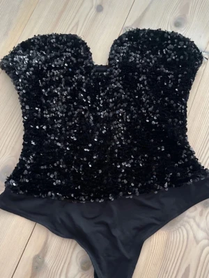 Svart paljettbody  - Snygg svart body täckt med glittrande paljetter upptill. I storlek M men passar S! ❤️använd 1 gång, kommer ej till användning. Inga defekter!