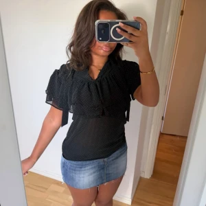 Svart prickig blus med volang - Säljer denna jättefina svarta prickiga blusen med volangdetaljer vid ärmarna och bröstet💞