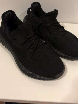Svarta Yeezy Boost 350 V2 sneakers - Svarta Yeezy Boost 350 V2 sneakers i storlek 42 passar även 41. Skorna är fåtal använda och kommer utan box. Kan gå ner i pris vid snabb affär. Skriv gärna om ni har några frågor!