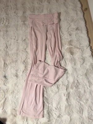 Ljusrosa yogapants gina - Supersköna ljusrosa yogapants med låg midja och utsvängda ben. Perfekta för chill hemma eller mysiga dagar. Tillverkade i ett mjukt och stretchigt material som sitter bekvämt mot kroppen. Det är barnstorlek i beskrivningen. Pris kan diskuteras 