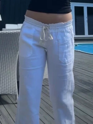 Vita linnebyxor  - Säljer ett par jätte fina vita linnebyxor med bred resår i midjan. Byxorna har stora fickor fram och bak. Perfekta för en chill och stilren look under varma dagar. Materialet är svalt och luftigt linne.