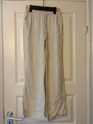 Linnebyxor  - Beiga lågmidjade linnebyxor från H&M i storlek xxs, passar dig som är runt 155cm lång. Finns fickor och så att man kan knyta i midjan. 