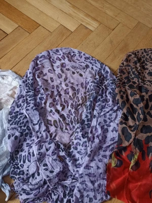 Ljusblå och vit tunn halsduk - Säljer en tunn och mjuk halsduk i ljusblått och vitt med lätt skrynklig struktur. Perfekt att slänga över axlarna för en chill och avslappnad look. Materialet känns luftigt och passar bra till olika outfits.