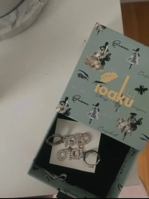 Ioaku örhängen - Snygga silvriga ioaku statement örhängen i bra skick. Inga defekter hur som helst och super fina. Snygga med motivet yolo. Köpta för ett tag sen men använder mest guld smycken.