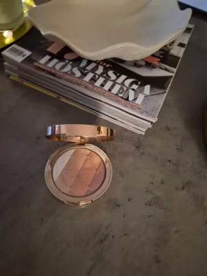 Charlotte tilbury highlighter palett - Highlighterpalett från Pigeon’s Talk med tre skimrande nyanser: champagne, roséguld och ljus pärlemor. Kommer i en rund, guldig dosa med spegel i locket. Perfekt för att ge glow till ansiktet och framhäva kindbenen. Testad och swatchad. Färgen Romance Light . Lyxig förpackning.