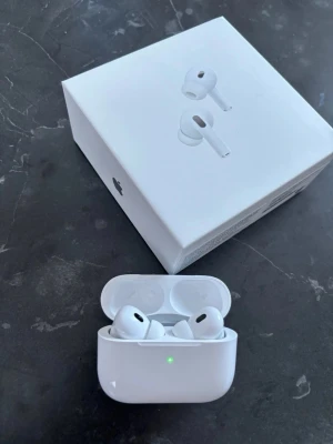 Apple AirPods Pro med MagSafe-laddning - Säljer ett par vita Apple AirPods Pro med MagSafe-laddningsetui. Trådlösa in-ear-hörlurar med aktiv brusreducering, silikonproppar i olika storlekar och USB-C laddkabel. Snygg och stilren design i plast, perfekt för musik och samtal. 1800kr för ett par, 2 par för 3000kr