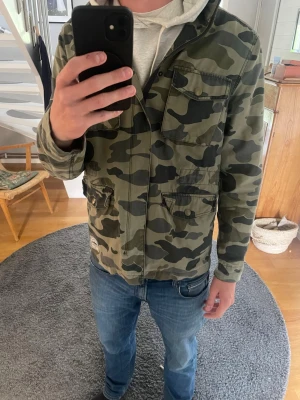 Camo Overshirt M - Camo overshirt i Storlek M/170. Modellen på bilden är 187cm så skulle säga den passar M. Den är från HM men sällsynt. Bra kvalite. Vid frågor kom DM!😊