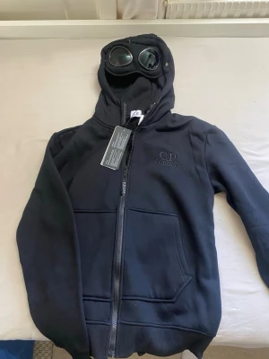 C.P. Company hoodie svart - Säljer en helt ny svart hoodie från C.P. Company, passar som storlek S
