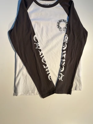Chrome Hearts Long Sleeve - Säljer en Chrome Hearts long sleeve i vitt med bruna ärmar, storlek M.  Clean färgkombination och skön passform. Fint skick.  Storlek: M Färg: vit / brun  Skickar gärna fler bilder eller mått vid intresse.