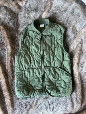 Trendig Olivgrön quiltad dunväst från zara - Quiltad khaki/olivgrön väst från Zara. Storleken är 140 men den är större i storleken och skulle säga mer S/M💕 
